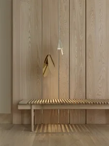 Minimalist wooden bench in a contemporary setting with a unique pendant light hanging above it.