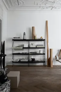 A modern interior featuring black metal shelves with books and decorative items.