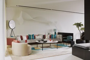 A modern living room with neutral tones, featuring a round beige couch, a low coffee table with decorative items, colorful th
