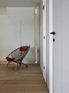 A minimalist living room with a wooden woven chair and minimalist decor.