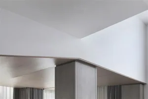 A minimalist interior space featuring wooden elements and light tones.