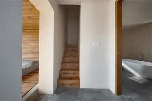 現代簡約室內空間，天然木質樓梯搭配白牆與混凝土地板。