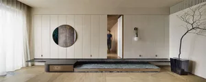 Modern living room with wooden floor, marble coffee table, concrete walls, and metal accents.