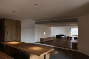 A modern minimalist living room featuring wooden elements and a large window.