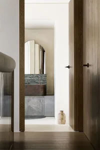 A minimalist bathroom featuring a concrete countertop and brass fixtures, showcasing modern design elements.