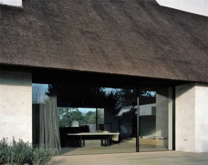 A minimalist exterior with a thatched ridge roof.