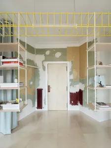 Minimalist room featuring wooden furniture, rope shelves, and metal accents.