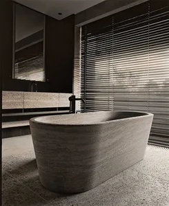 A modern bathroom with a freestanding bath made of concrete, featuring a concrete floor and walls, and a window with horizont