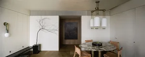 Modern dining room with marble table and minimalist design elements.