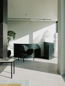 Modern interior design featuring black metal chair and glass partition
