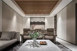 Modern living room with marble centerpiece table, leather recliners, and glass vase with purple flowers.