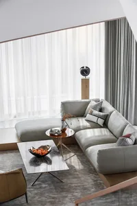 A modern living room with light grey sectional sofa and minimalist decor.