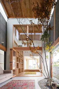 Interior of a modern living space featuring wooden beams, concrete flooring, and corrugated metal walls.