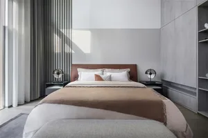 A minimalist bedroom with a neatly made bed, soft lighting, and a sleek, modern design.