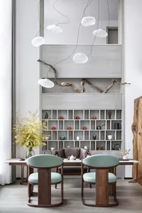 Modern minimalist living room with wooden furniture and shelves, featuring a cozy seating area and stylish decor.