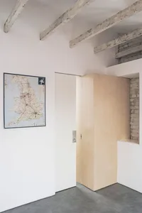 Minimalist interior design featuring wooden paneling and a map on the wall.