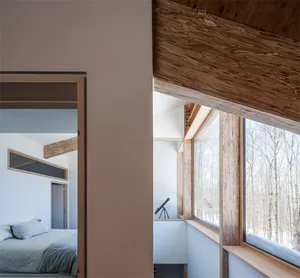 A minimalist residential space featuring wooden walls and windows.