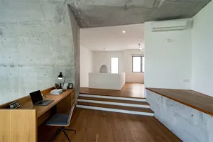 A modern home office space featuring concrete and wood elements, designed for functionality and style.