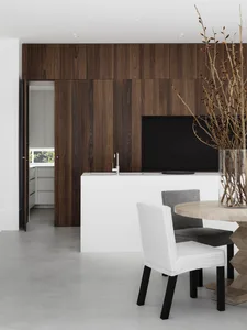 Modern kitchen with concrete flooring, wooden island, and dining area.