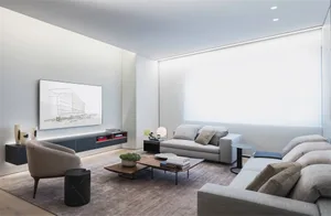 Contemporary modern minimalist living room setting featuring light-colored furniture, grey sofa, and light brown armchair wit