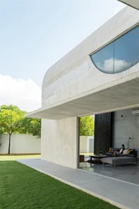 A modern house with a concrete exterior, large windows, and a sleek, minimalist design.