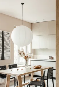 Minimalist kitchen featuring wooden table, glass vase of dry flowers, and concrete cabinets