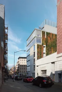 An exterior view of a modern living building with a green wall.
