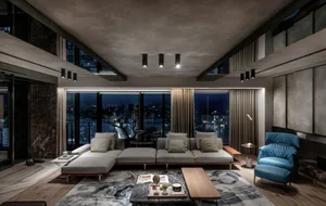 Modern living room featuring a large sofa and floor-to-ceiling windows overlooking a cityscape at night.