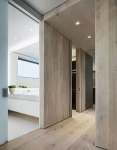 Modern minimalist bathroom featuring wood flooring and white fixtures.