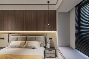 Modern minimalist bedroom featuring a wooden bed frame, white sheets, and gray headboard with a nightstand and bench.