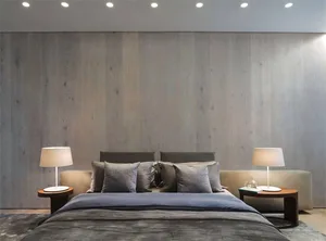 A minimalist bedroom with a wooden texture wall, grey bedding, and matching bedside tables with lamps.