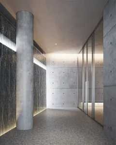 A minimalist industrial corridor with concrete walls, a waterfall, and glass walls.