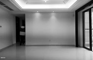 A minimalist living room with a concrete floor and a person walking.