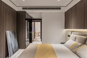 A modern bedroom with wooden paneled walls, a bed with white and yellow bedding, and a sleek, minimalistic design.