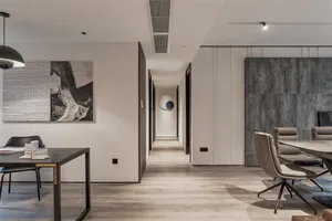 Modern dining room with mixed materials, including a wooden floor, black and white abstract painting, concrete finish wall, a