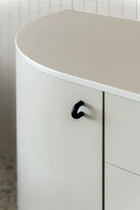 A minimalist interior design featuring a white counter top and cabinets made of concrete.
