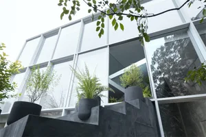 Concrete planters with greenery in front of an industrial-style building.