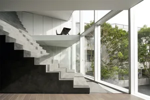 A modern living space featuring concrete and glass elements.