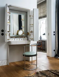 White dresser with brass accents and marble top, featuring a vanity mirror and storage compartments.