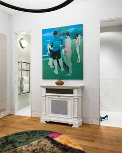 A modern living room with wooden floor and a large painting of people standing at the seaside.