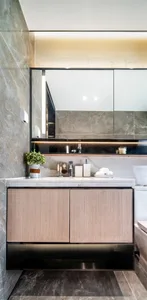 A modern bathroom vanity unit made of marble and wood materials, featuring a mirror cabinet above.