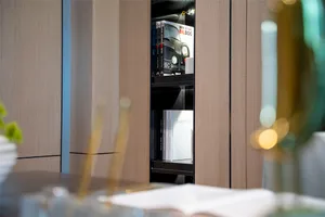A modern interior storage solution featuring wooden cabinets and books.