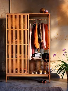 A modern wooden wardrobe with open shelves, clothing hung, and shoes on the bottom shelf.