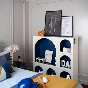 Modern bedroom with white and blue color combination, featuring a bed, shelves, and various items such as a lamp, posters, an
