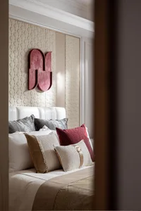 A modern bedroom with a brown color scheme and a variety of pillows on the bed.