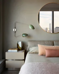 A minimalist bedroom featuring a contemporary bedside lamp and a large window overlooking a cityscape.