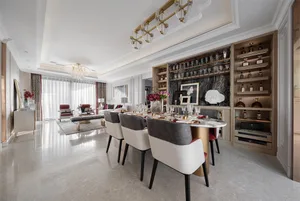 Modern dining room featuring marble table and chairs, with a bar area and wine rack.