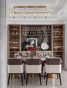 A modern dining room featuring a table surrounded by chairs, with shelves displaying wine bottles and glasses, and decorative