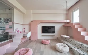 A minimalist living room with a pink and terrazzo mix, featuring a flat-screen TV, comfortable seating, and a pink step-and-p