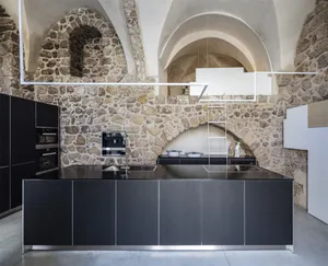 Modern industrial kitchen with stone walls and black metallic surfaces